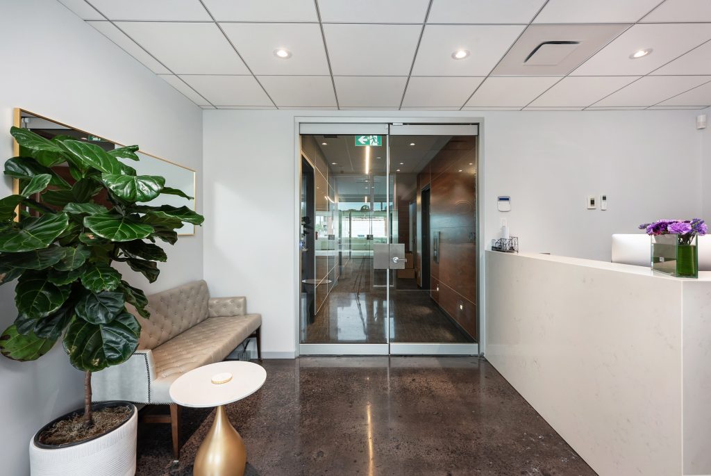 Renovated commercial office reception area with glass doors and polished concrete floor