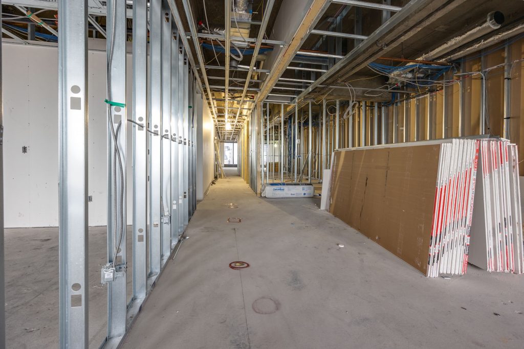 Corridor under construction with metal stud framing, Fortex Construction project